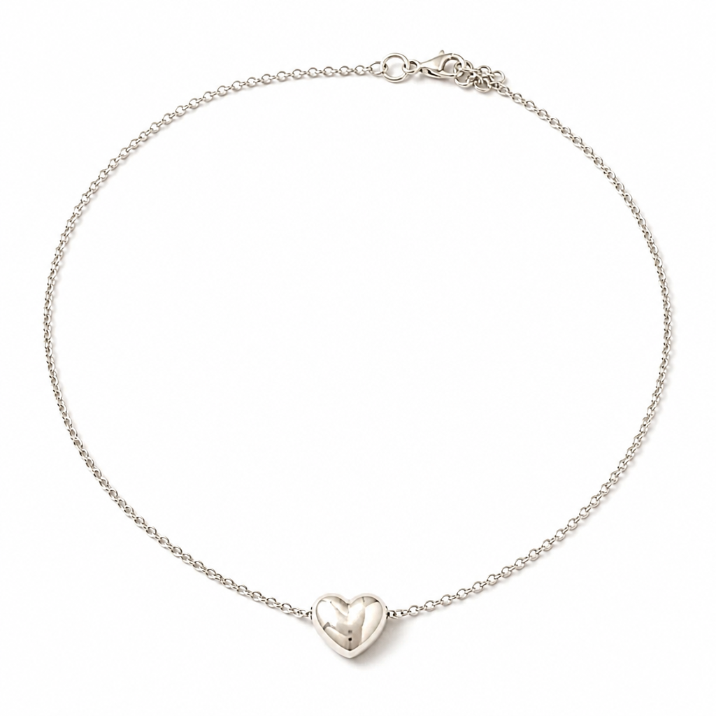 A silver chain necklace with a small, polished silver heart pendant