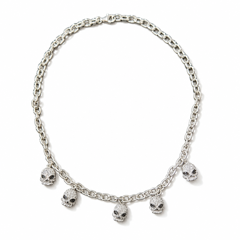 A silver-toned chain necklace featuring five dangling skull charms, each embellished with small clear stones